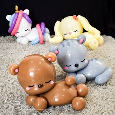 three small plastic toys are laying on the floor together and one is holding an infant's head