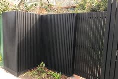 a black fence is next to a brick walkway