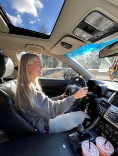 a woman sitting in the driver's seat of a car