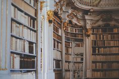 an old library with many bookshelves and stairs