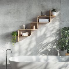 a white bath tub sitting next to a wooden shelf filled with books and planters