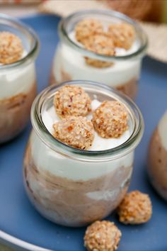 desserts in small glass jars on a blue plate with white frosting and oatmeal