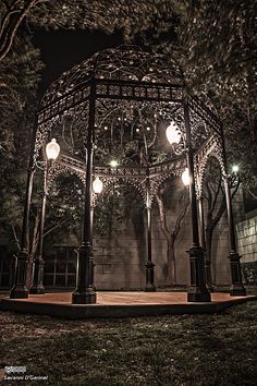 an outdoor gazebo lit up at night