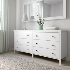 a white dresser and mirror in a room