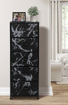 a black and white chest of drawers in a room