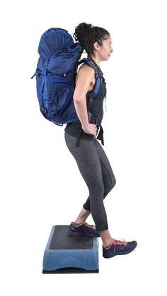 a woman with a backpack is standing on a scale