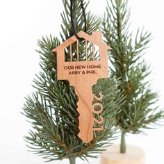 wooden key ornament hanging from a tree with the words our new home above it