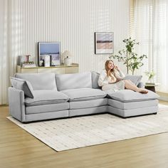 a woman sitting on top of a couch in a living room