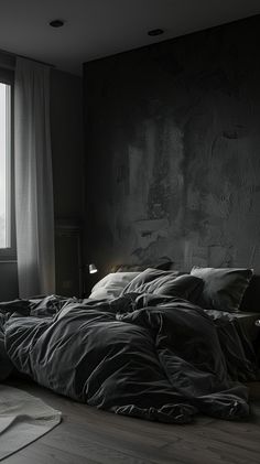 an unmade bed sitting in front of a window next to a rug and lamp