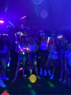 a group of young people standing around each other in front of purple and blue lights