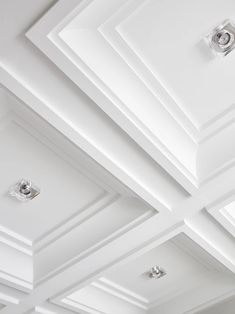 the ceiling is lined with recessed lighting and white walls, along with cofferns