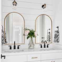 a bathroom with two sinks and three mirrors