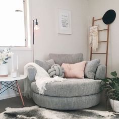 a living room with a chair, rug and potted plant on the side table