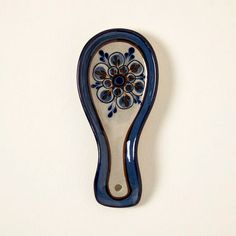 a blue and white ceramic object hanging on a wall