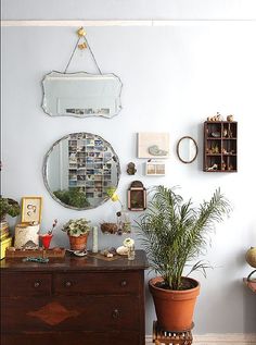 there is a potted plant on the dresser in front of the mirror and other decorations