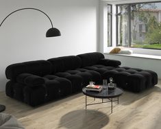 a living room with a black couch and coffee table in front of a large window