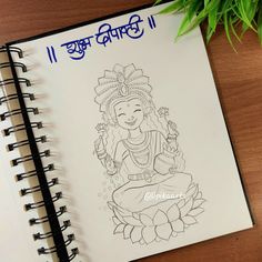 a notebook with an image of lord ganeshra on it next to a potted plant