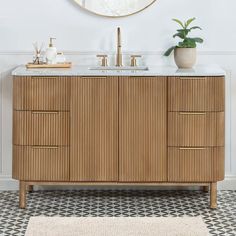 a bathroom vanity with two sinks and a mirror on the wall above it, along with a potted plant