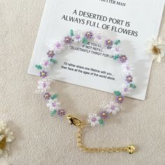 a bracelet with flowers on it sitting next to a card that says, a desired port is always full of flowers