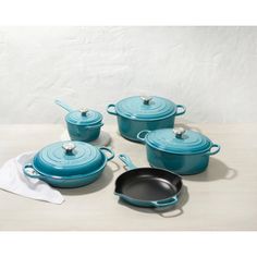 blue pots and pans are sitting on a table