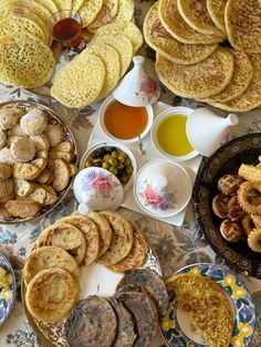 a table topped with lots of different types of food and condiments on plates