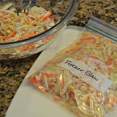 two bags of freeze - dried coleslaw sitting on top of a counter next to a bowl of shredded carrots