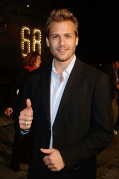 a man in a suit giving the thumbs up