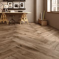 a room with wood flooring and pictures on the wall, along with two desks