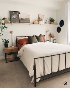 a bedroom with a bed, nightstands and pictures on the wall