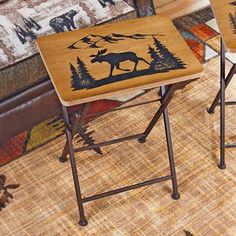 two wooden stools with moose designs on them