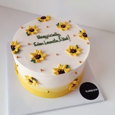 a birthday cake with sunflowers on it is sitting on a card board that says congratulations, green lemonade stash