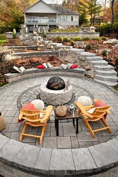 an outdoor fire pit surrounded by chairs and tables