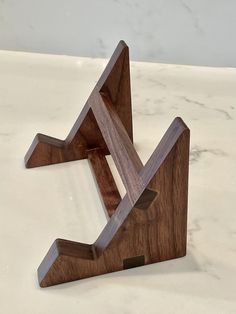 a wooden object sitting on top of a white table next to a marble countertop