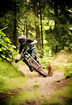 a person riding a dirt bike on a trail in the woods