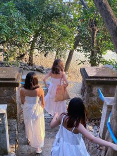 three girls in white dresses walking up stairs