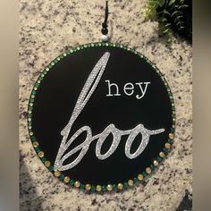 a black and white sign that says hey boo on the side of a stone wall