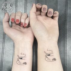 two women with matching tattoos on their arms holding coffee mugs and cups in their hands