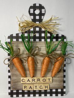 some carrots are hanging on a wall with the word carrot patch spelled in wooden letters