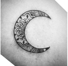 a crescent tattoo on the back of a man's stomach with an intricate design