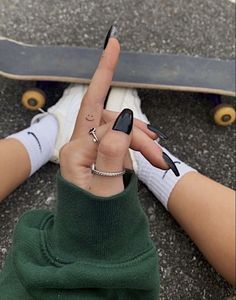 a person with their fingers in the shape of a peace sign and holding a skateboard