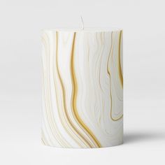 a candle that is sitting on top of a white surface with wavy lines in it