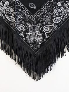 a black and white bandana with fringes on it's edge, laying flat