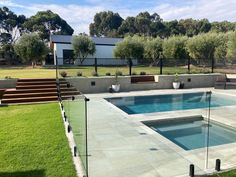 an empty swimming pool in the middle of a grassy area with steps leading up to it