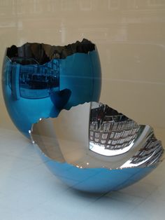 a blue and silver bowl sitting on top of a white counter next to a wall