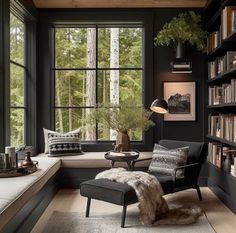 a living room filled with lots of books and furniture next to a window covered in windows