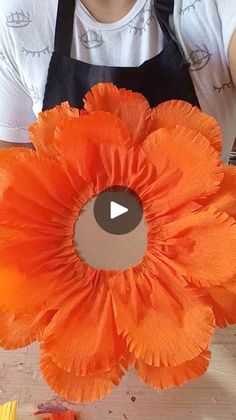 an orange flower being made with construction paper