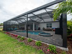 a house with a swimming pool in the middle of it's back yard and covered patio area