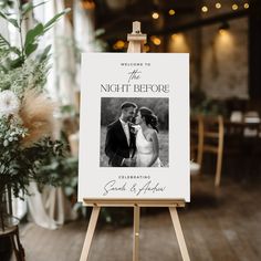 an easel with a wedding photo on it in front of a floral centerpiece