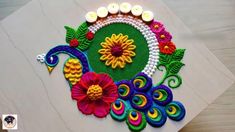 a decorated table with candles on it and flowers in the center, surrounded by beads