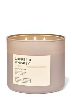 coffee and whiskey candle in a glass container with label on the front, sitting on a white surface